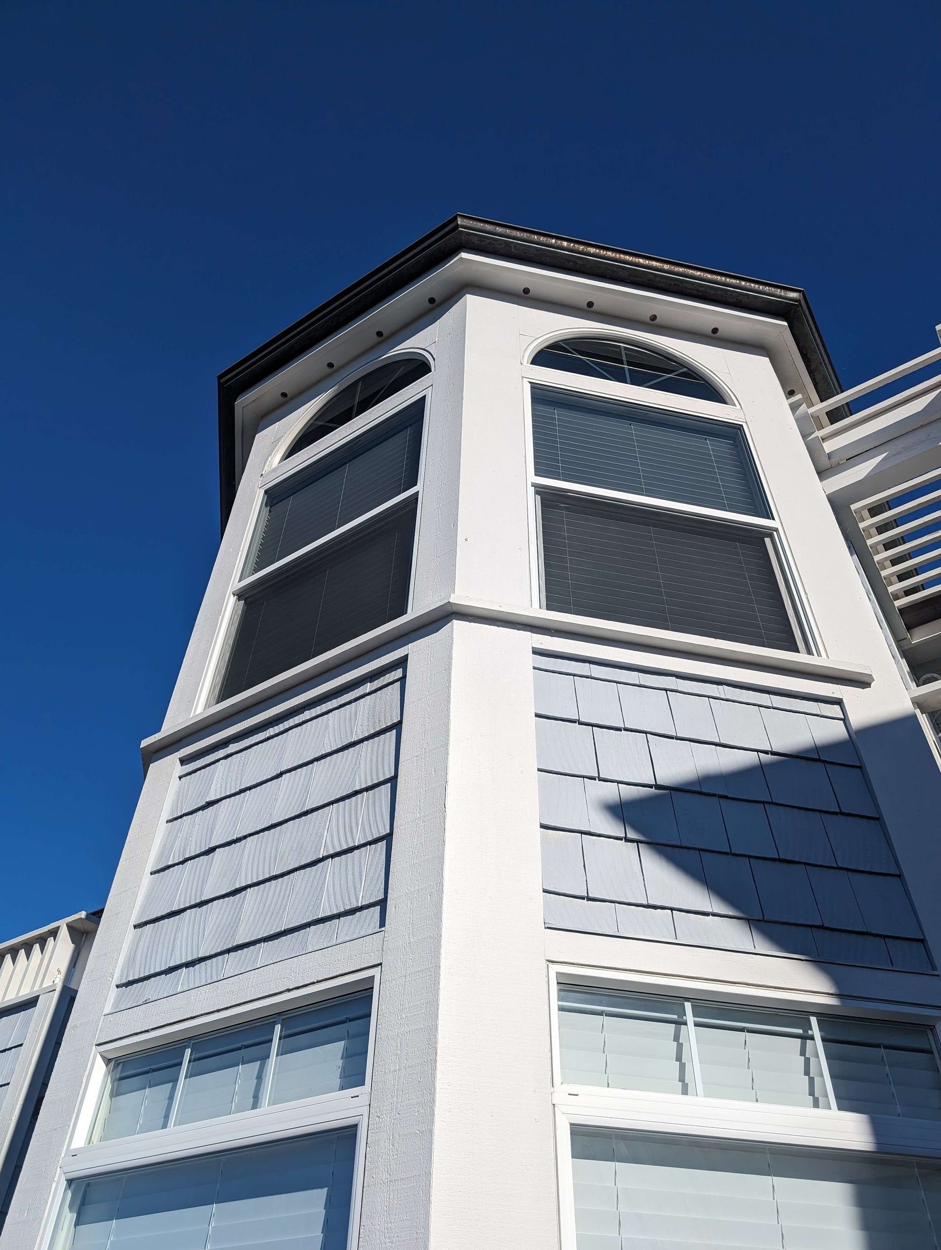 Looking up at a white building with a blue sky in the background