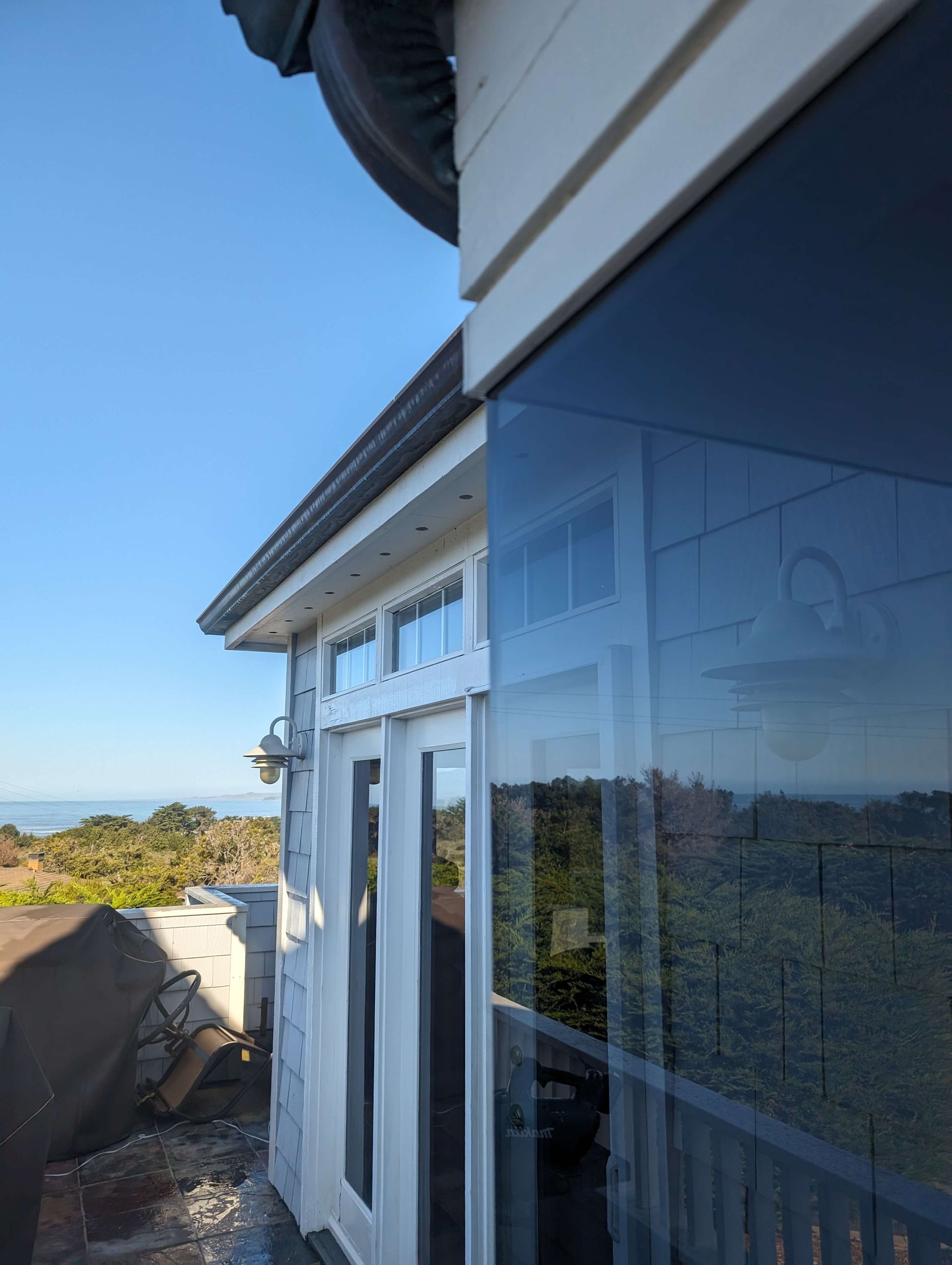 A house with a lot of windows and a view of the ocean