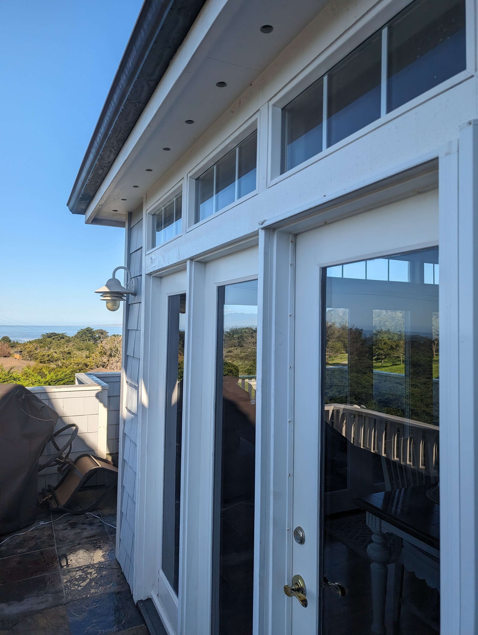 A white house with a lot of windows and sliding glass doors