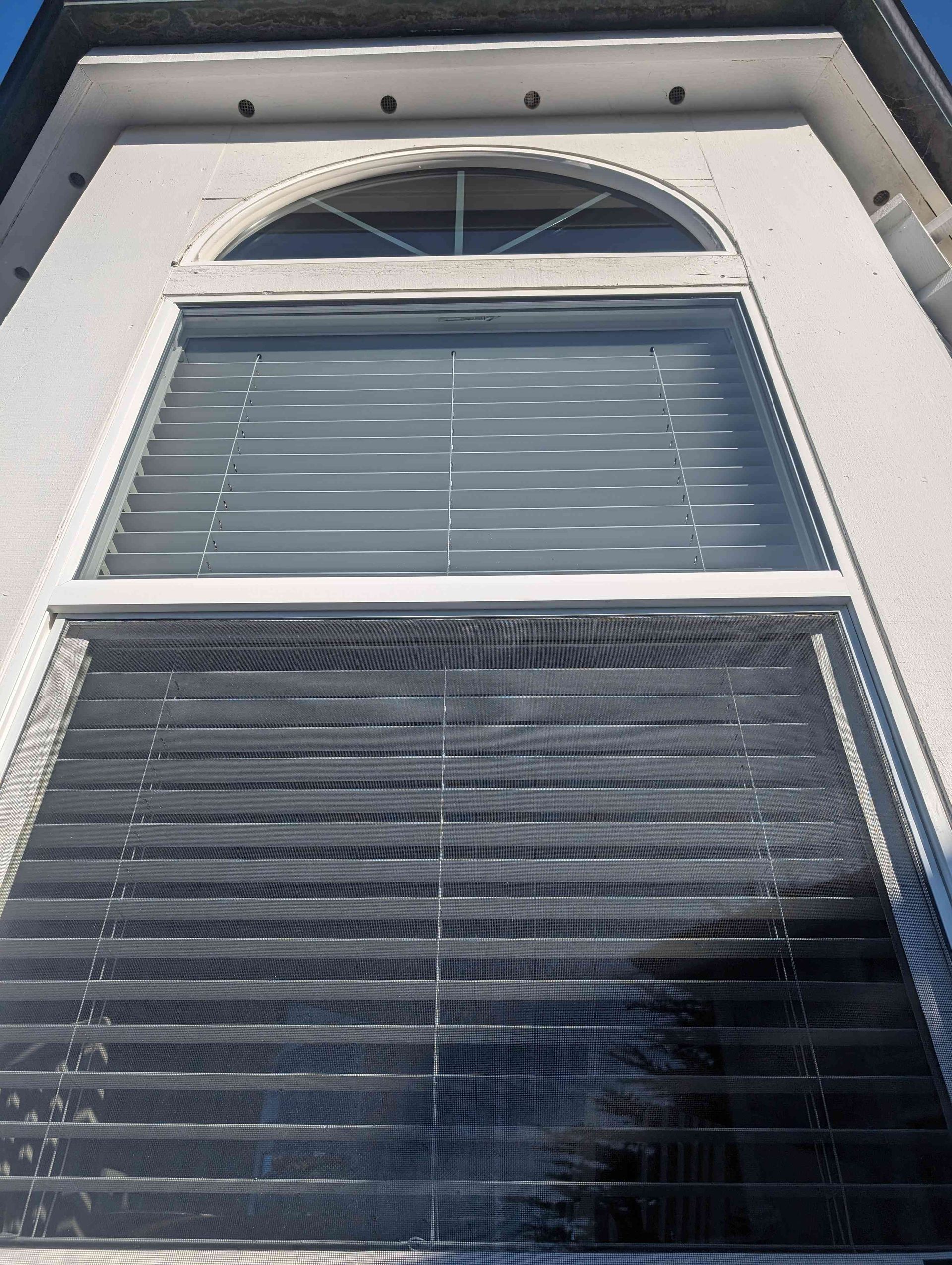 Looking up at a window with blinds on it