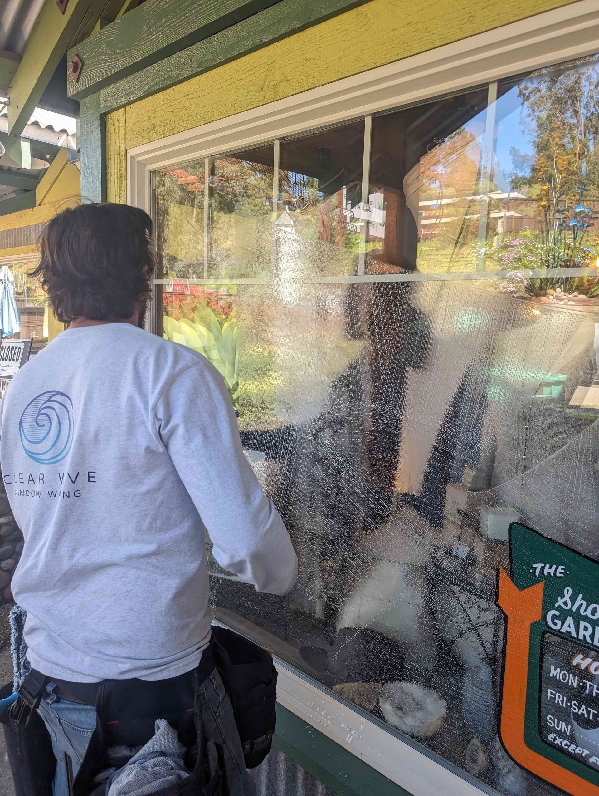 A man is cleaning a window outside of a building.