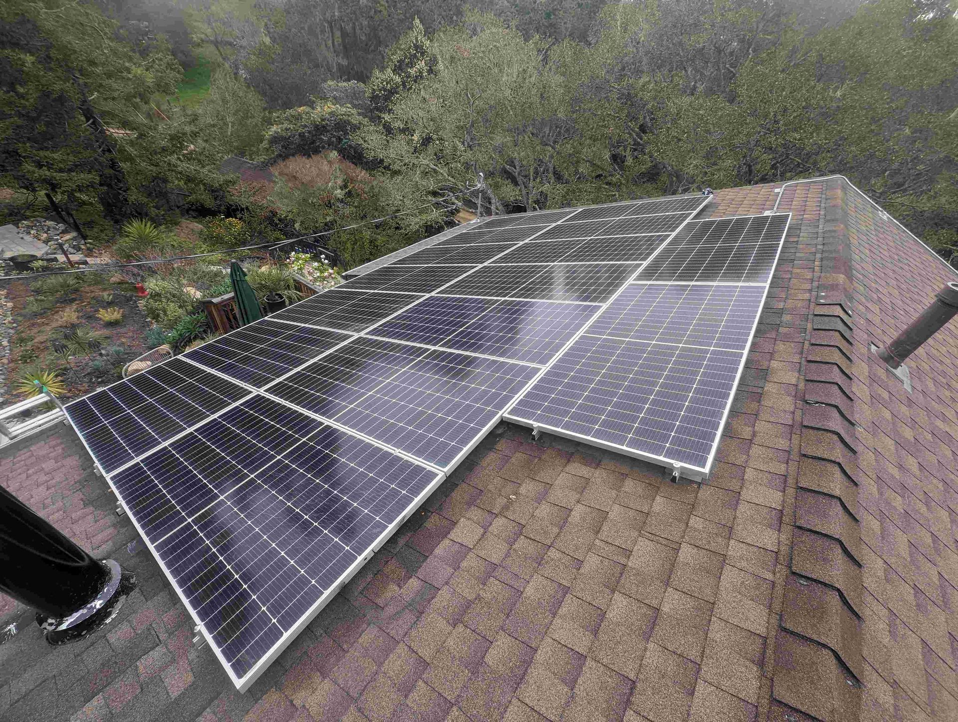 A row of solar panels are sitting on top of a roof.