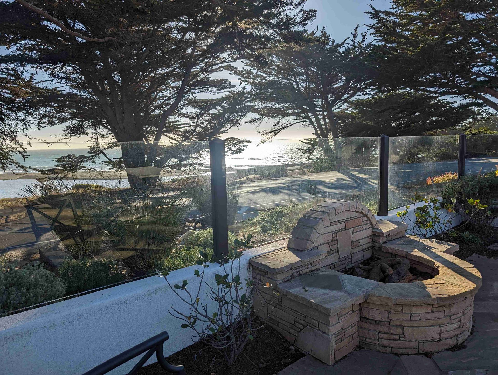 A fire pit on a patio with a view of the ocean.