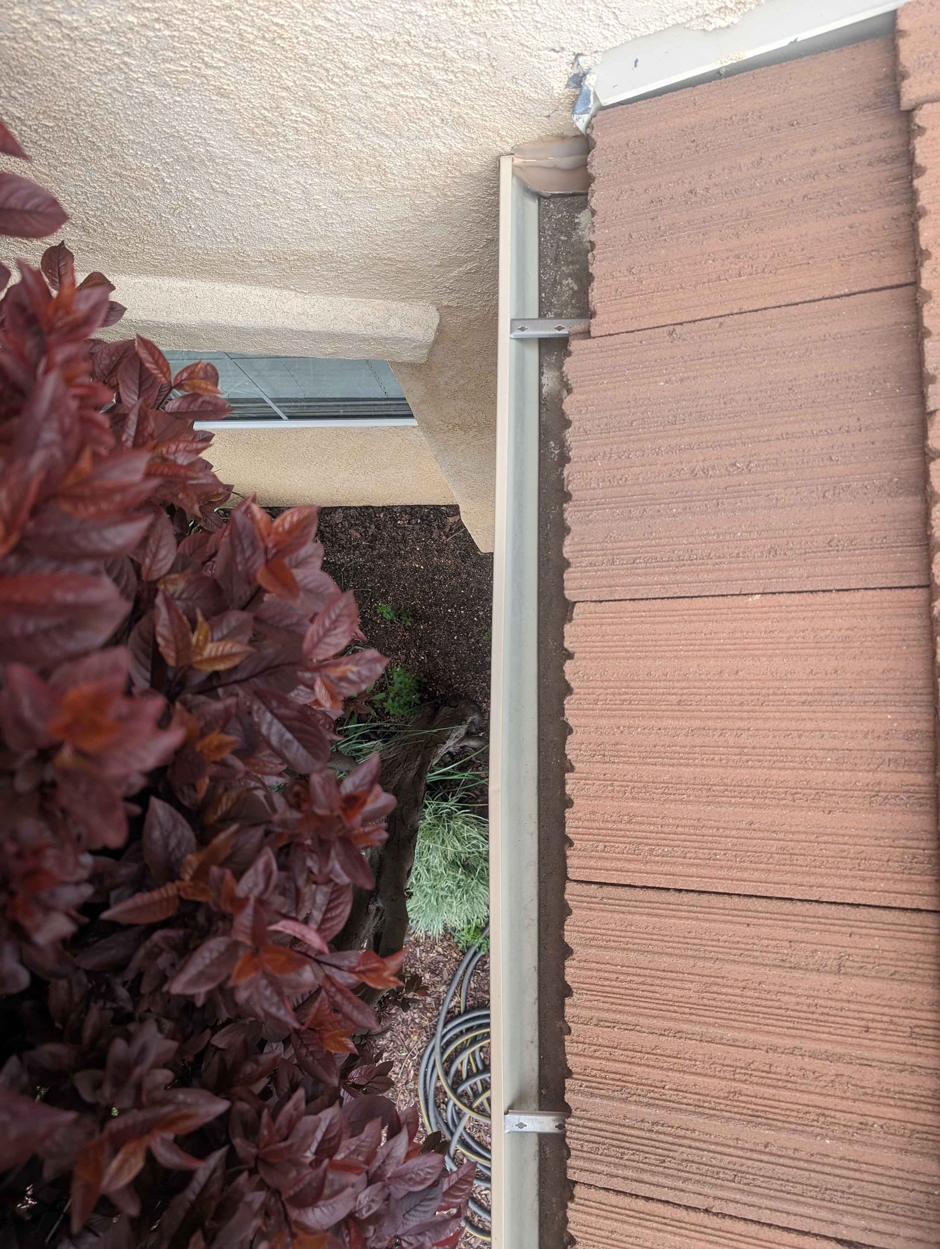 Brick building with a gutter on the side of it.