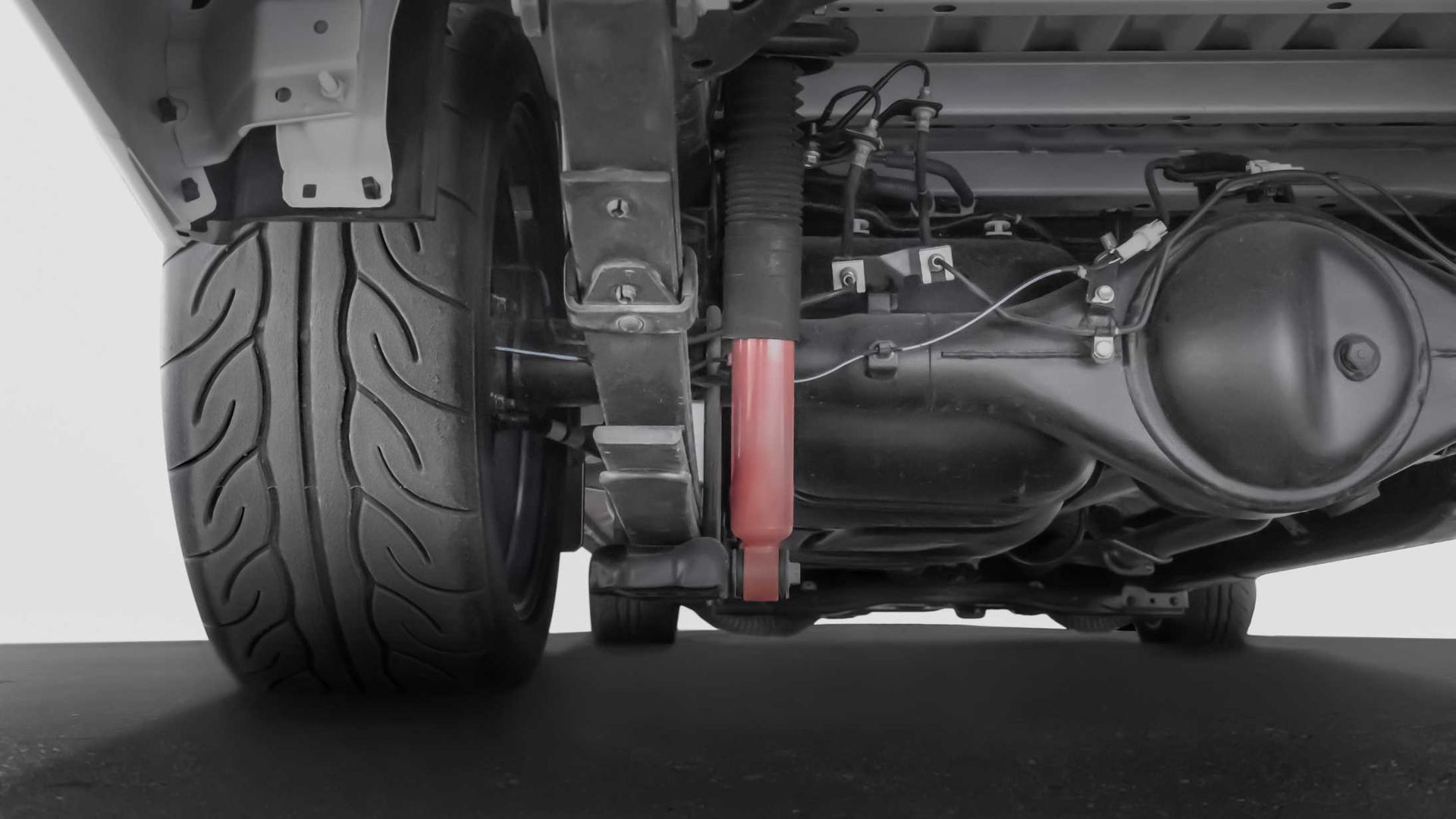 A close up of the underside of a car with a tire on it.