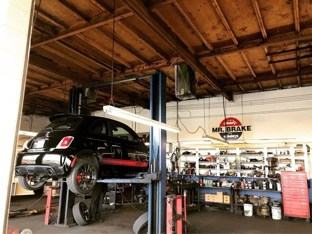 A close up of the underside of a car with a red brake caliper.