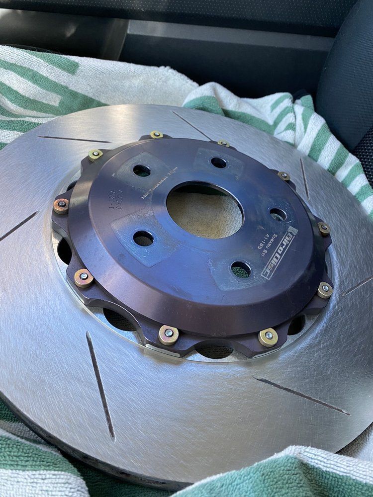 A person is fixing a brake disc on a car.