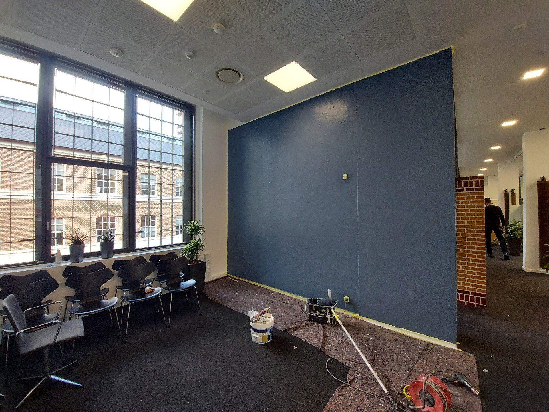 Et værelse med en blå væg og en støvsuger i