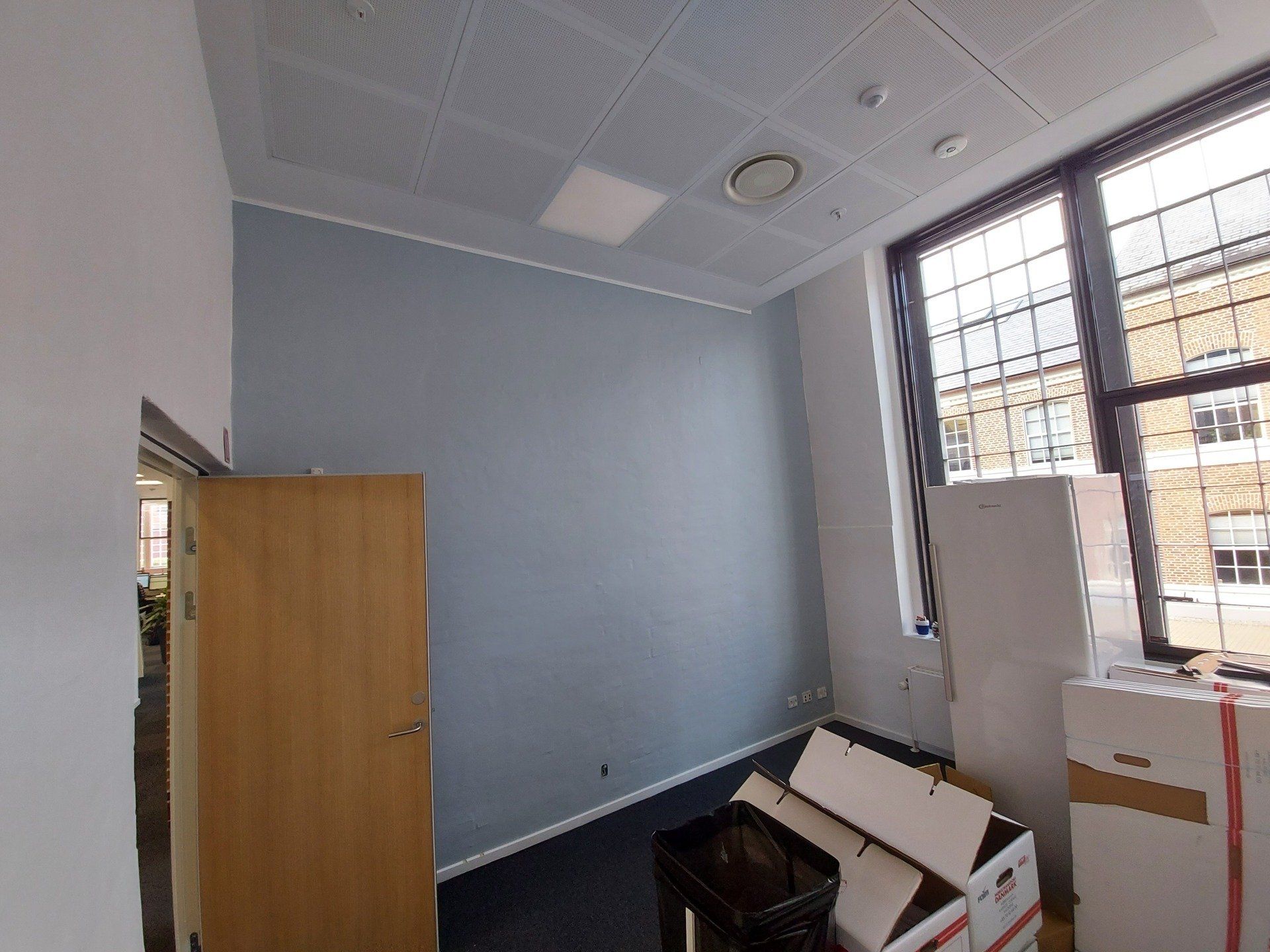 Et tomt rum med kasser på gulvet og en dør