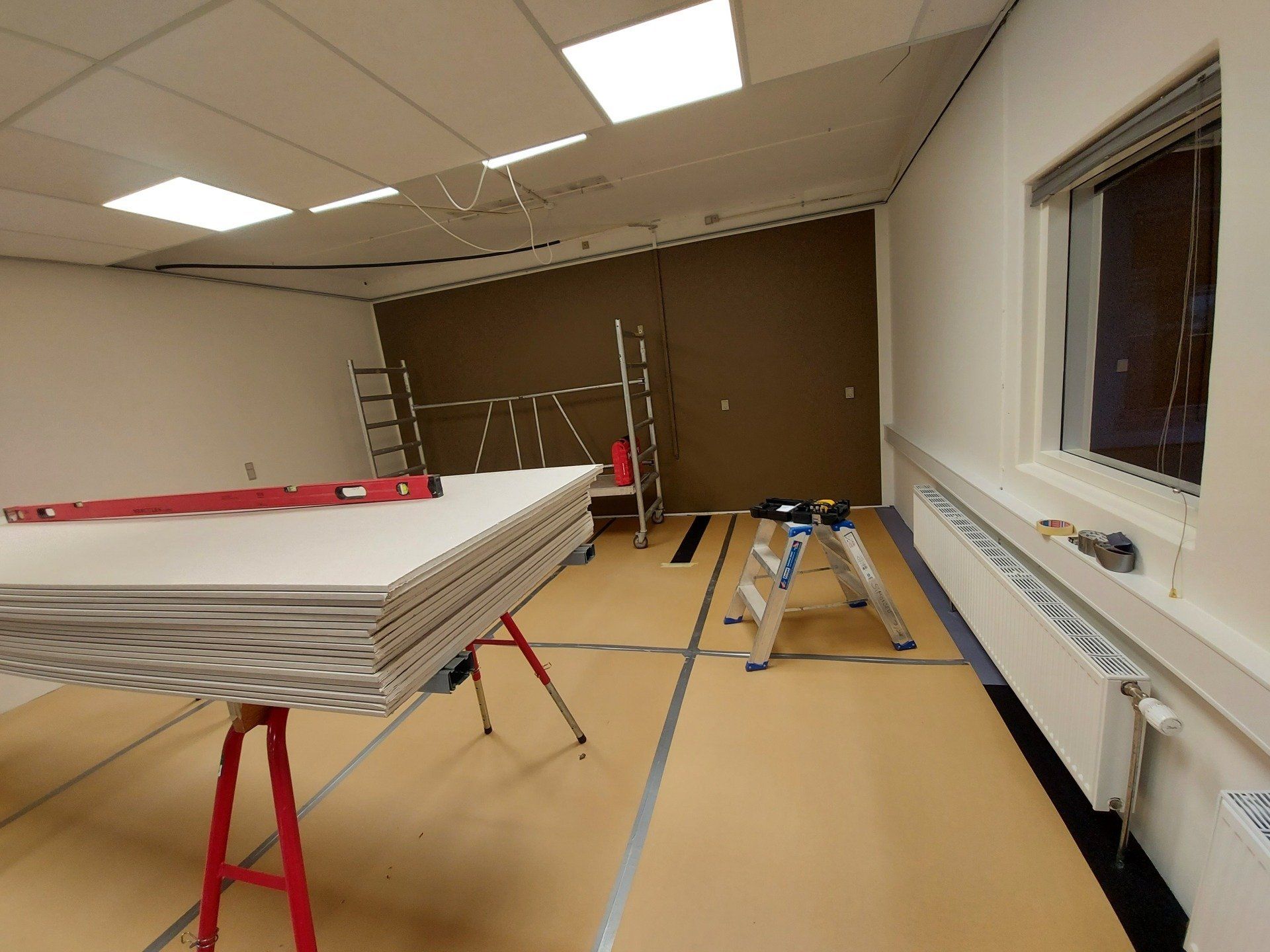 Et rum med en stige og en stak brædder på et bord