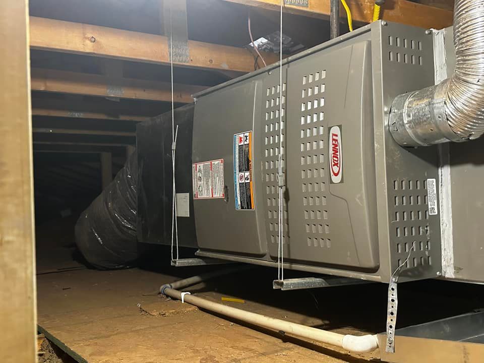 a furnace is hanging from the ceiling in a basement .