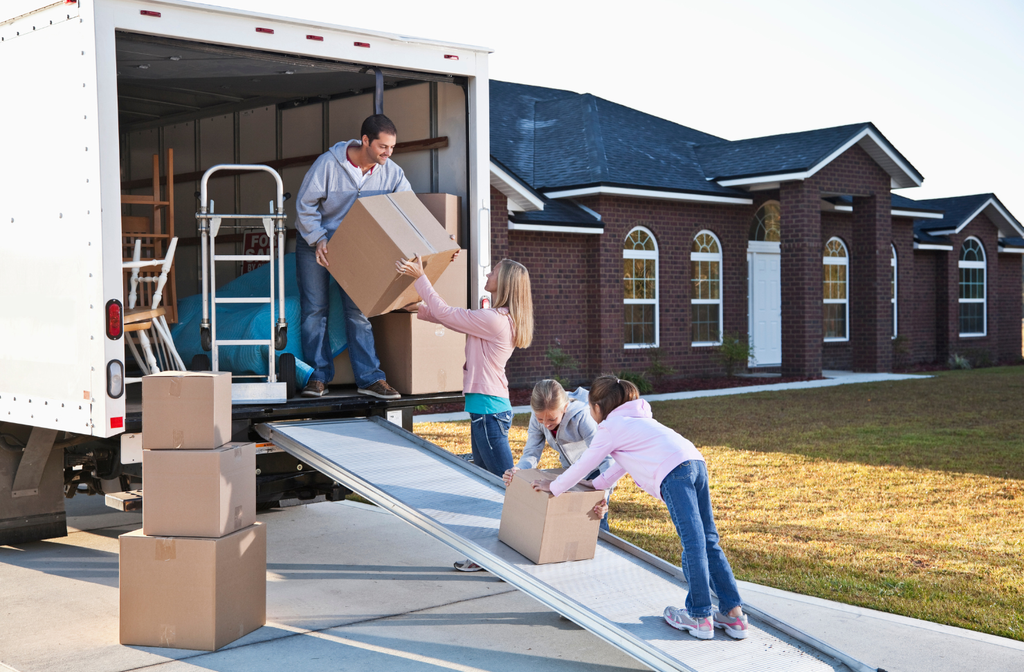 A family is loading boxes into a moving truck.