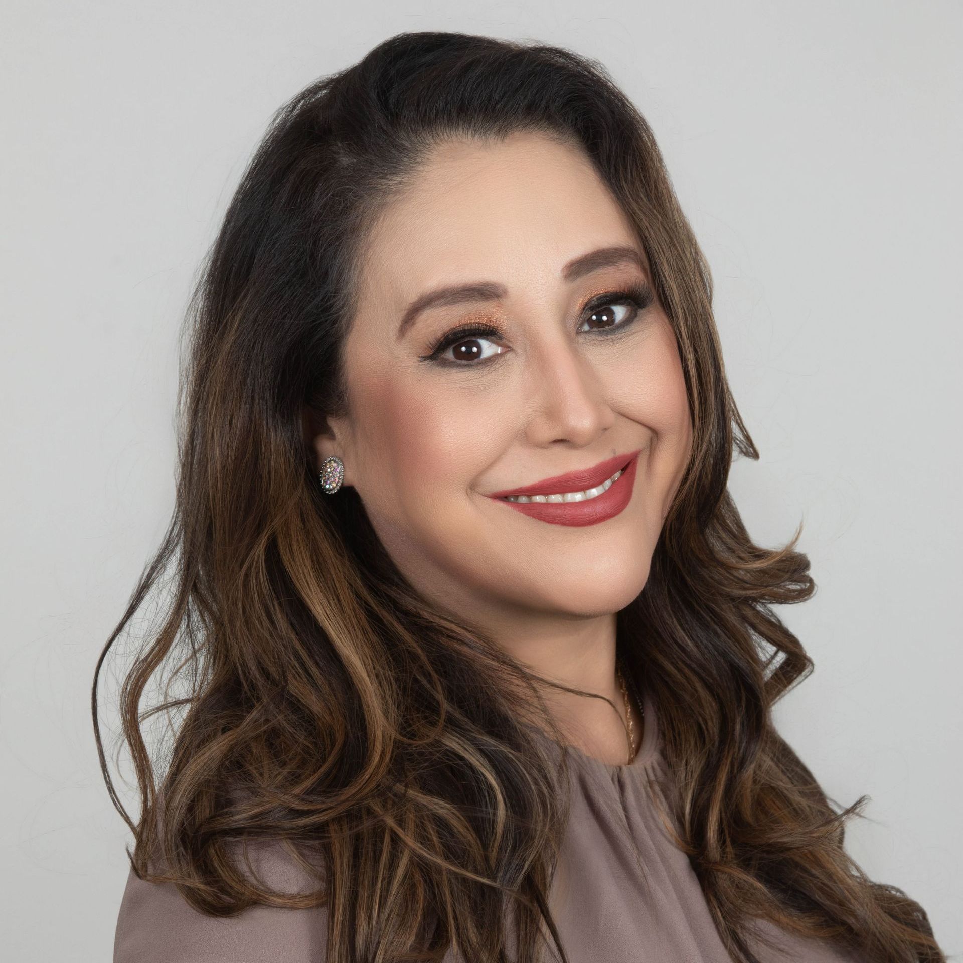 A woman with long brown hair is smiling for the camera.