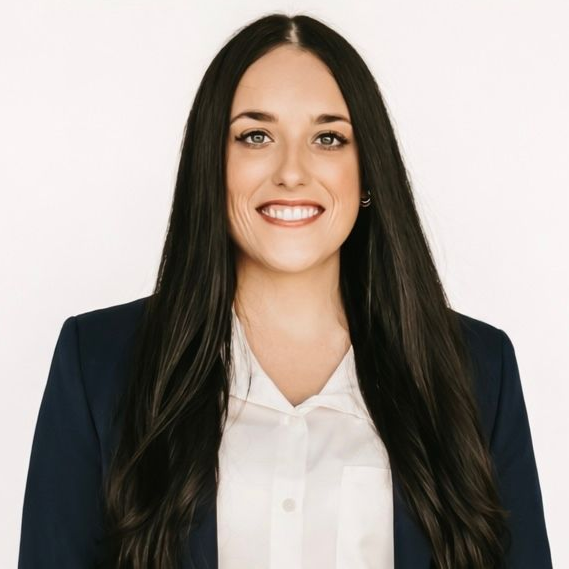 A woman wearing a green and white checkered shirt is smiling.