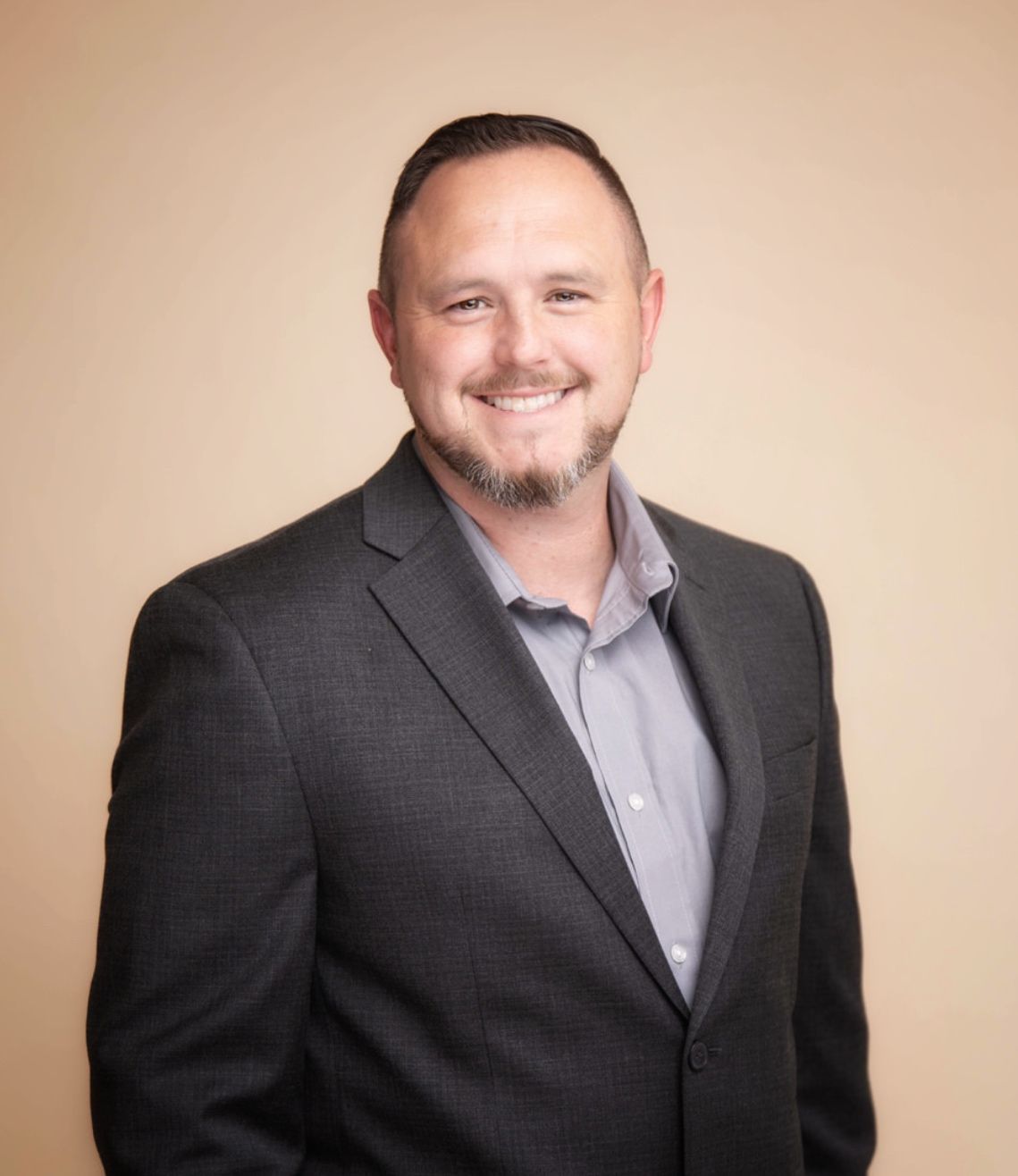 A woman wearing a green and white checkered shirt is smiling.