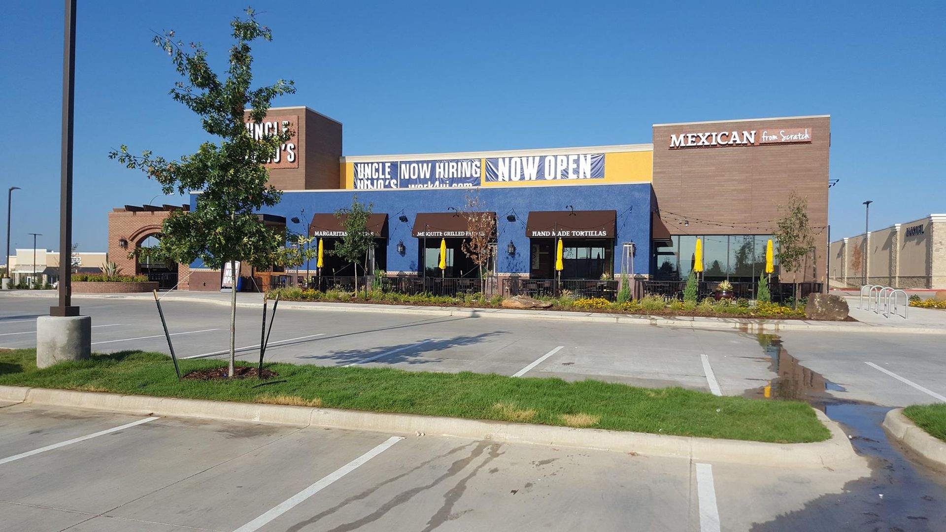 Exterior of a blue and brick Mexican restaurant with a parking lot.