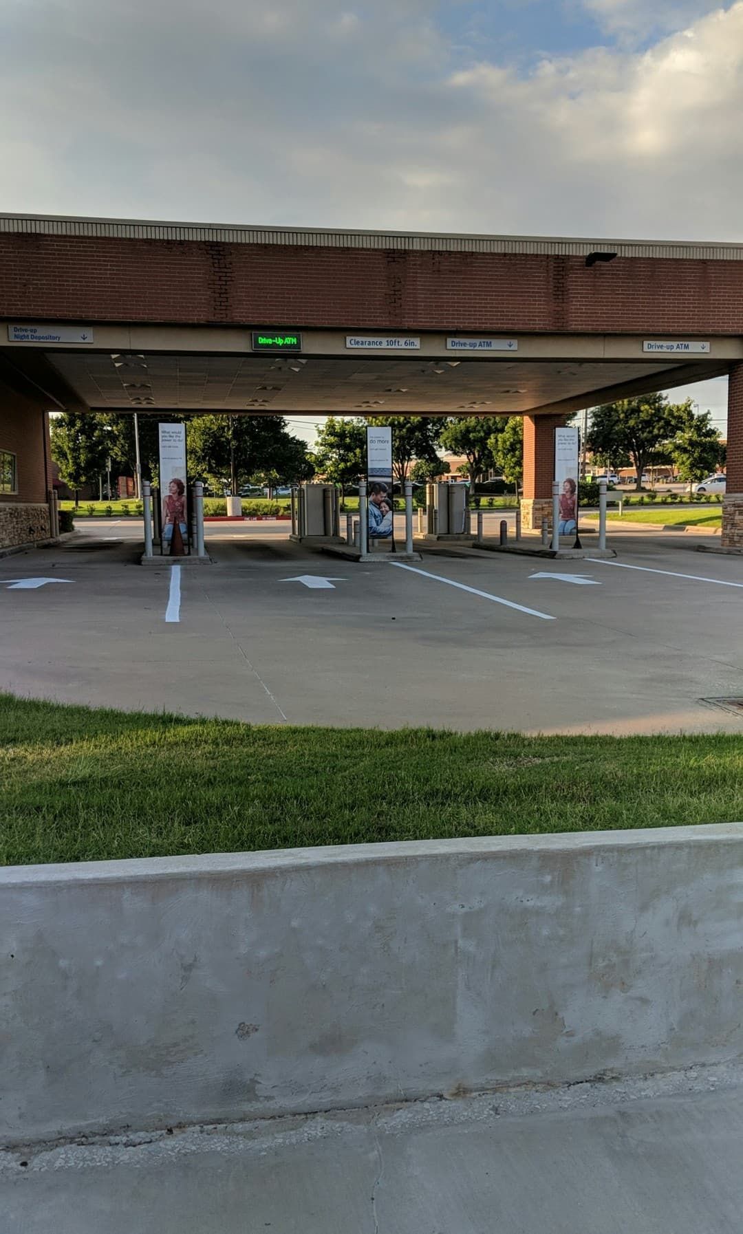 Drive-up bank teller lanes under a brick overhang; white arrows indicate drive-up directions.