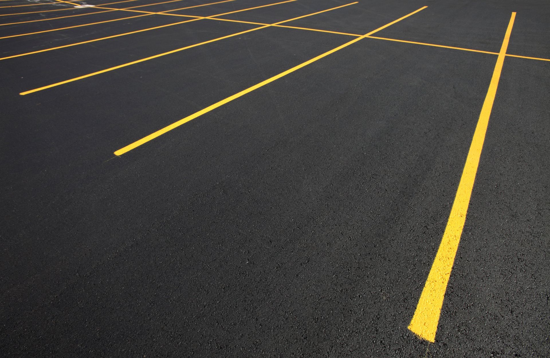 Yellow parking lines on black asphalt.