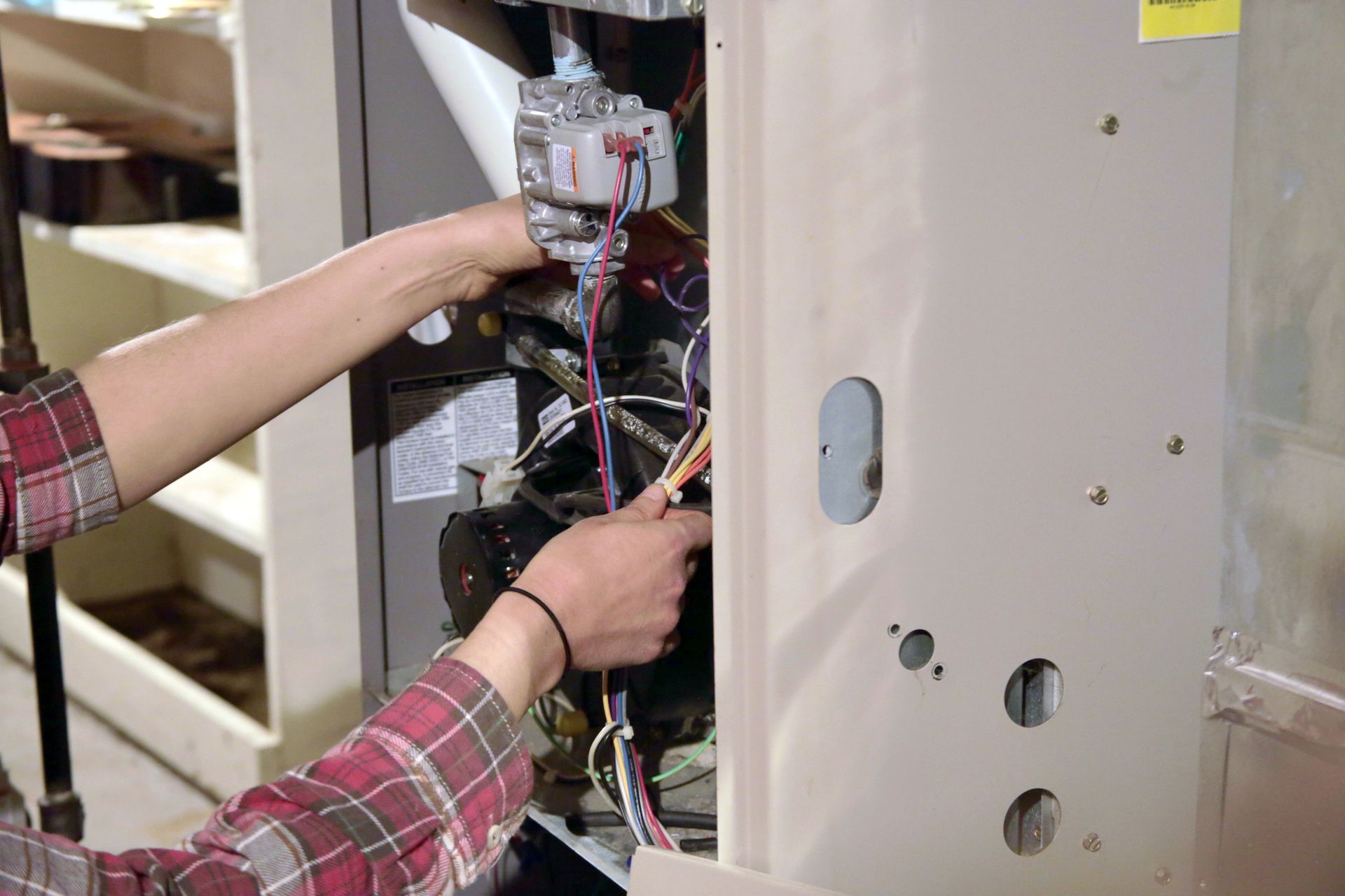 A person is working on a heating system in a room.