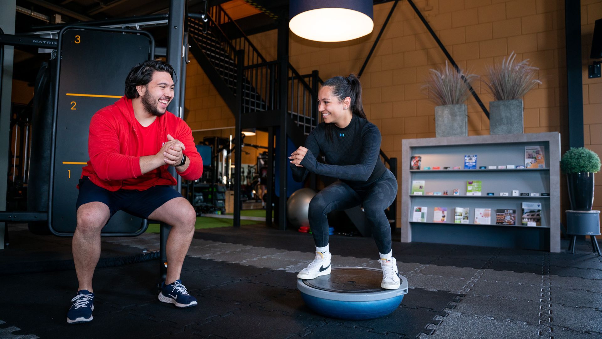 Twee mannen doen oefeningen met touwen in een sportschool.