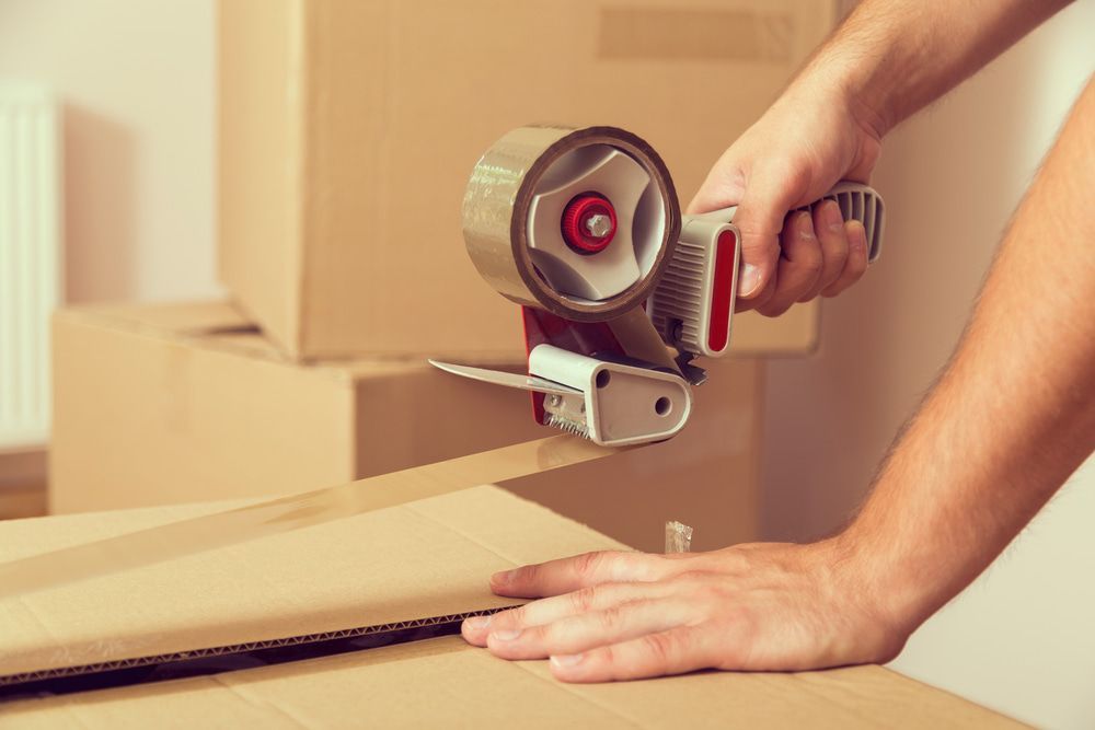 Using Tape to Seal A Cardboard Box — Twin Towns Removals Mid North Coast In Tuncurry, NSW