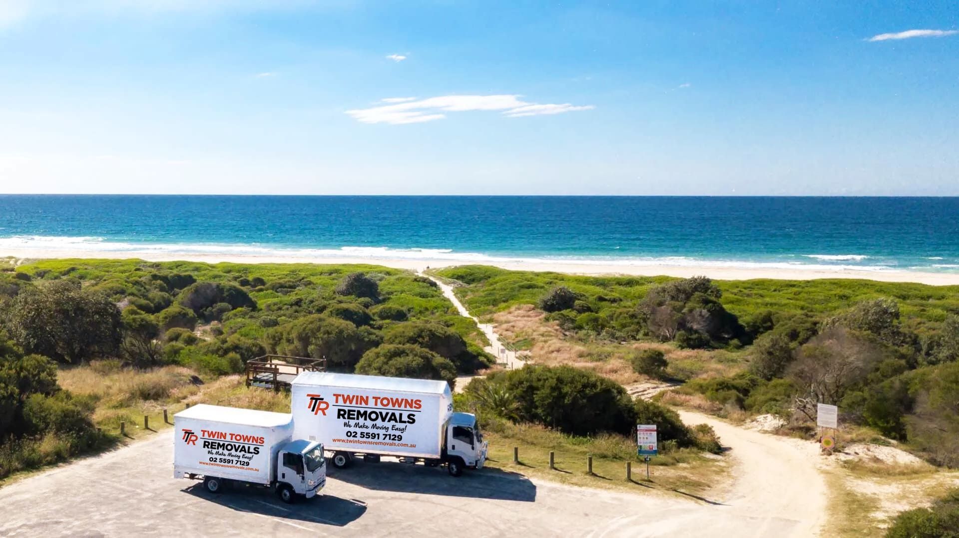 Two moving trucks traveling by beach — Twin Towns Removals Mid North Coast In Tuncurry