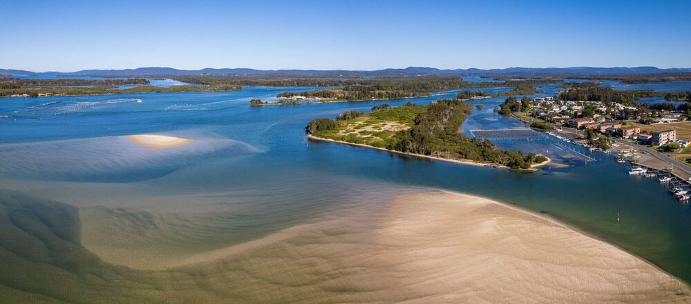 An aerial view of a body of water with a small island in the middle.