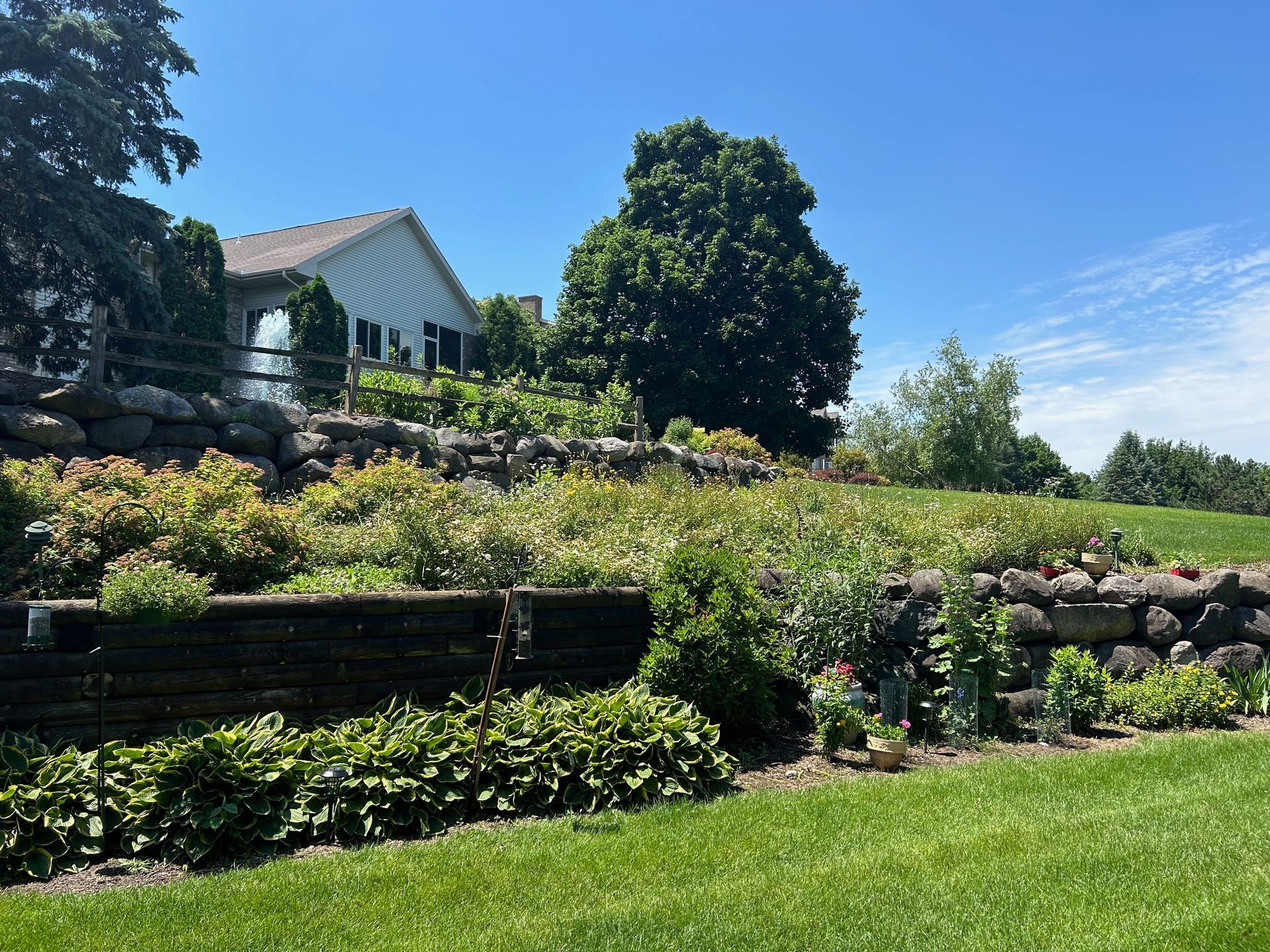 A white house is sitting on top of a hill next to a lush green field.