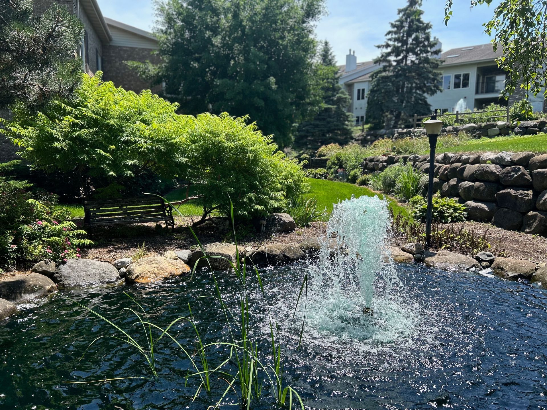 There is a fountain in the middle of the pond.