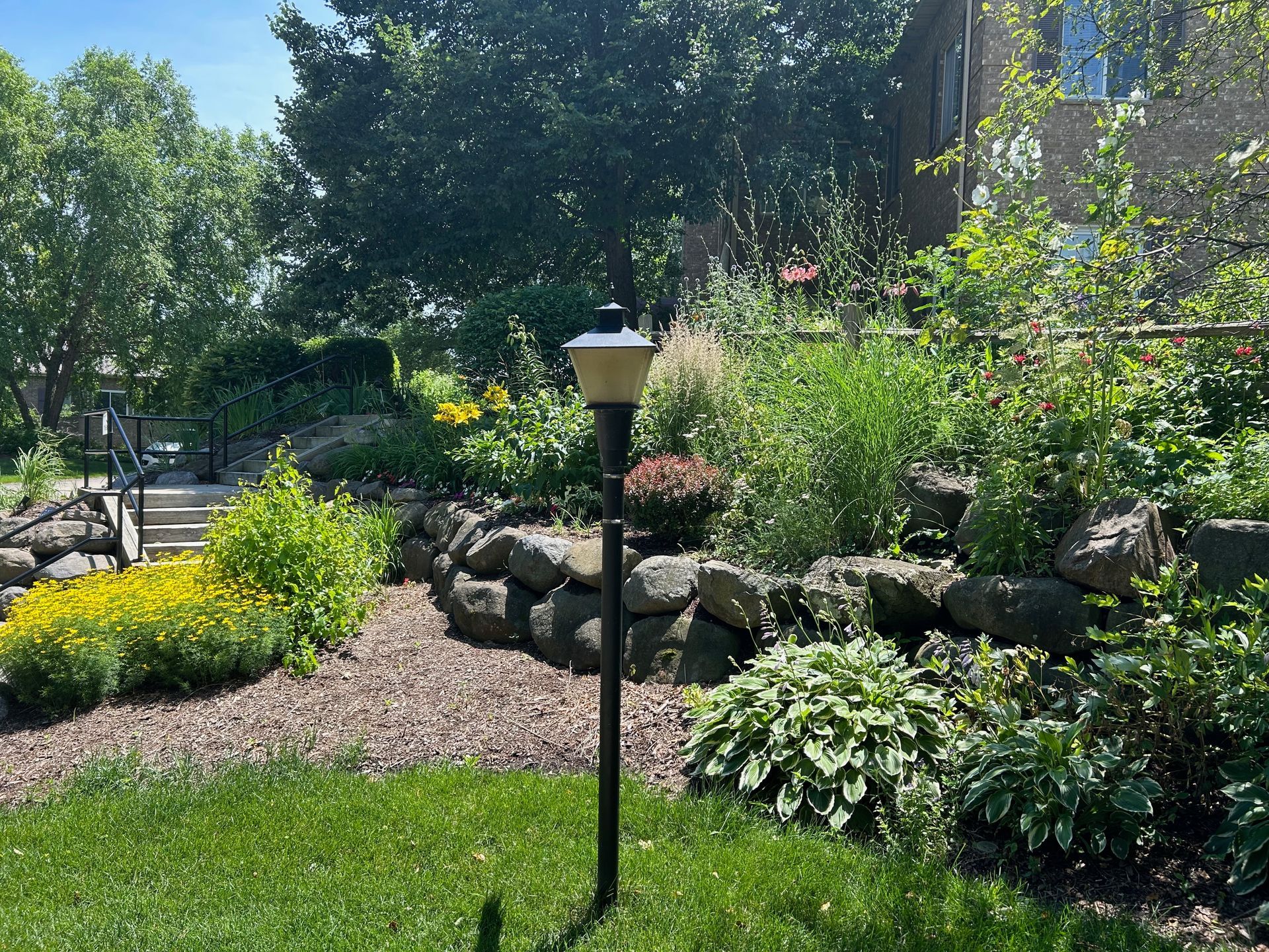 There is a lamp post in the middle of the garden.