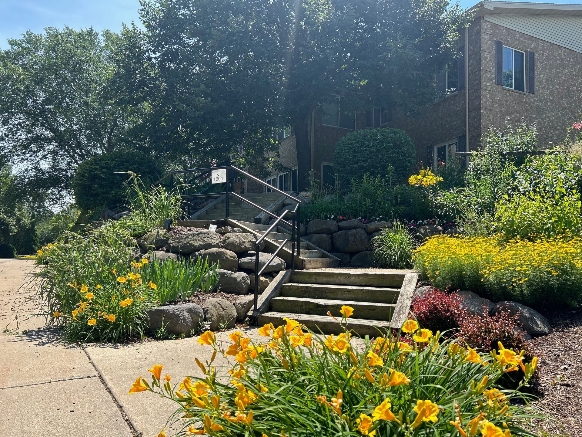 A brick building with stairs and flowers in front of it