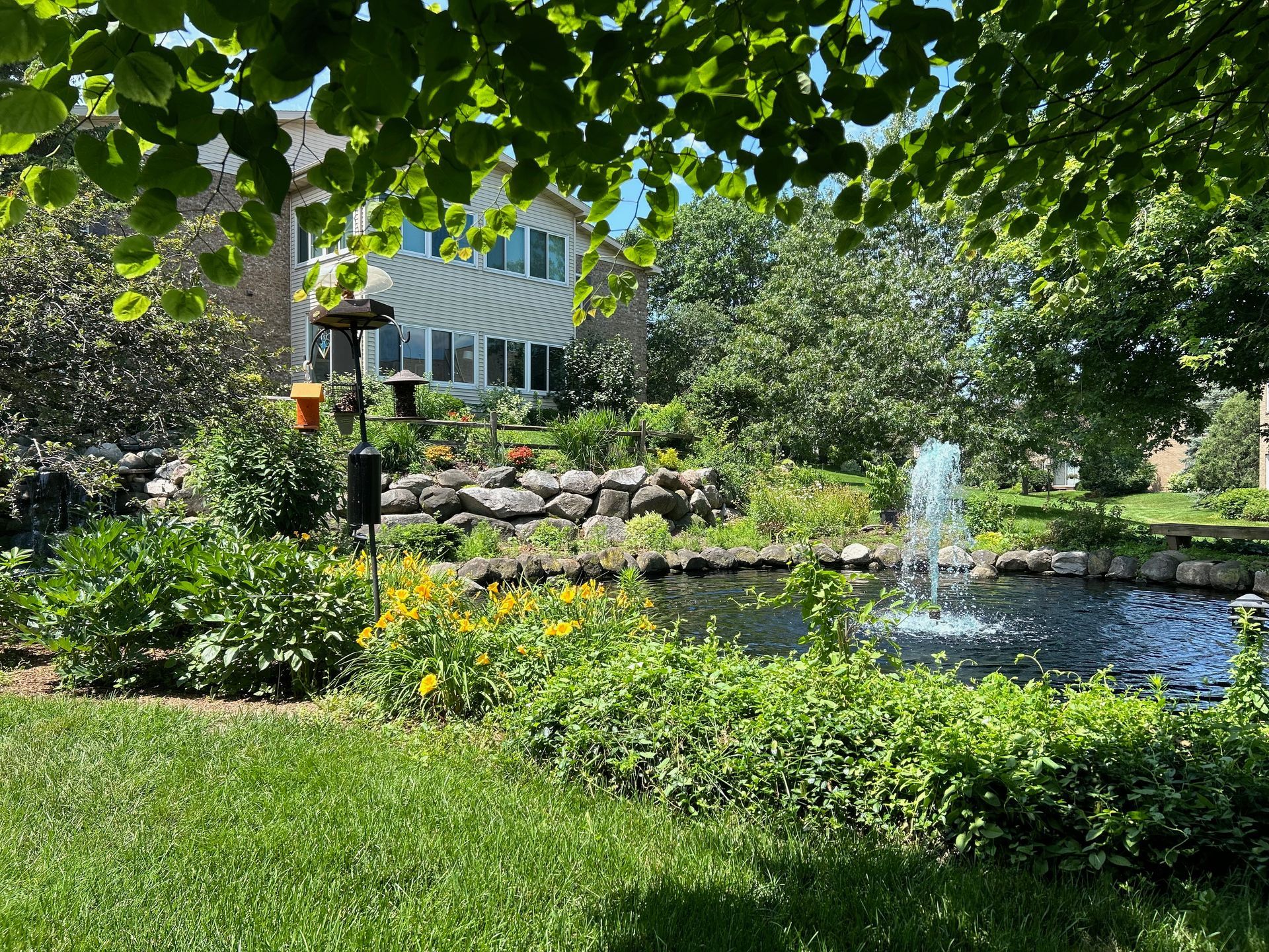There is a pond with a fountain in the middle of the garden.