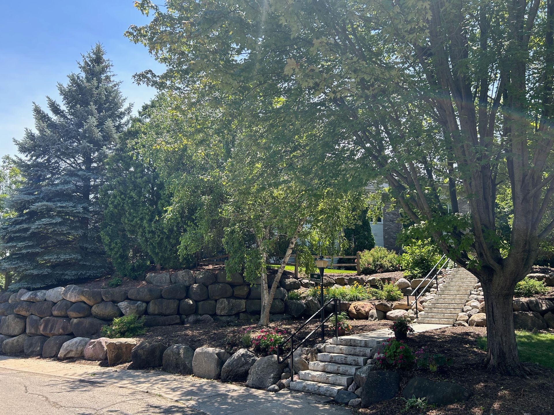 A stone wall with stairs leading up to it and trees in the background.