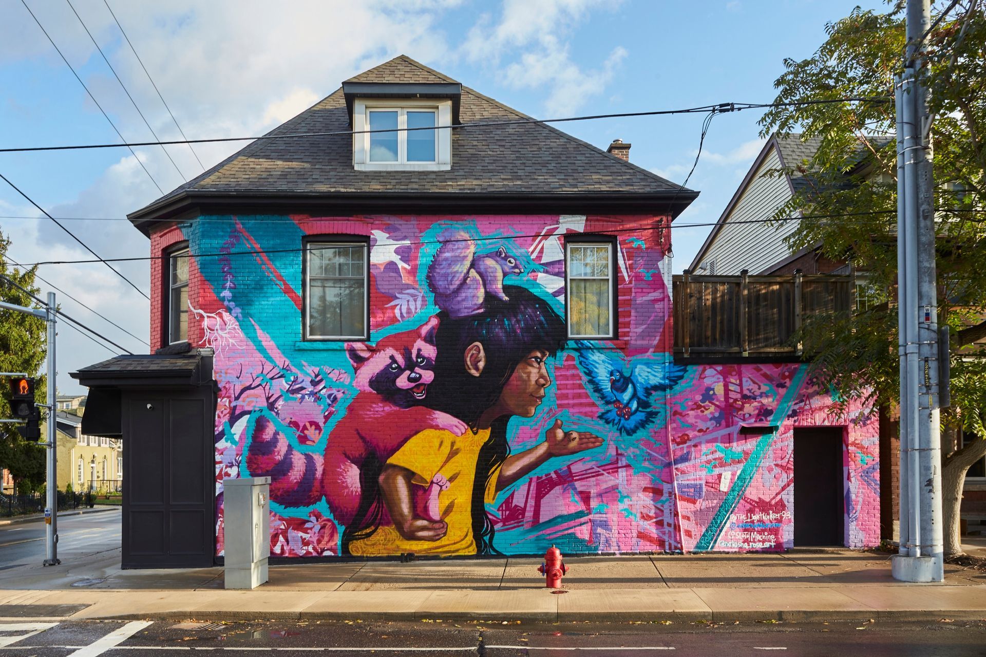 A colorful mural on a building depicts a child blowing a kiss. 