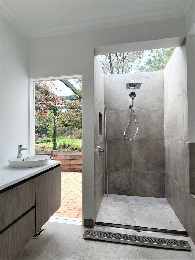 A Bathroom With A Walk In Shower And A Sink — Crampton Painting & Decorating Pty Ltd In Maiden Gully, VIC