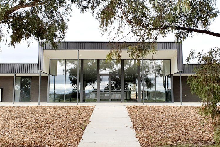 A Large Building With A Lot Of Windows And A Walkway Leading To It — Crampton Painting & Decorating Pty Ltd In Maiden Gully, VIC