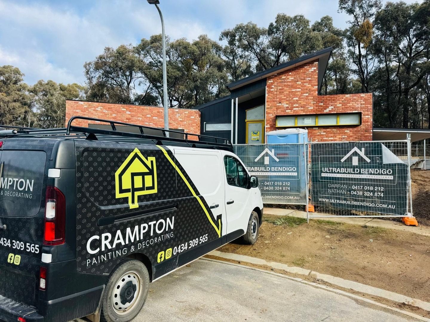 Black and white van parked in front of a brick house under construction, Crampton painting logo on the van — Crampton Painting & Decorating Pty Ltd In Maiden Gully, VIC