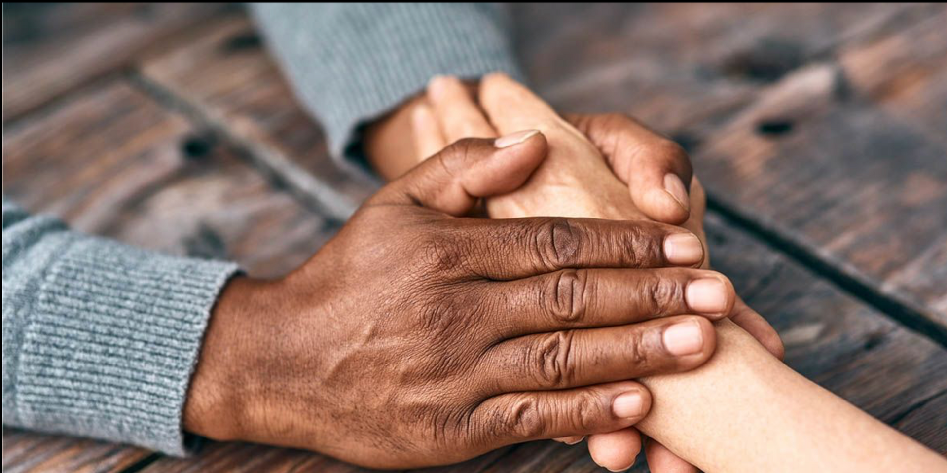 A close up of a person holding another person 's hand.