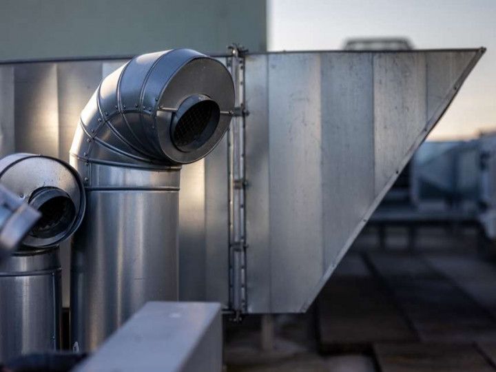 A close up of a metal pipe on the side of a building.