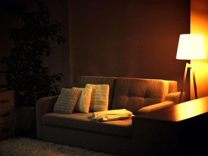 A living room with a couch and a lamp