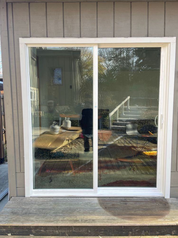 A white sliding glass door is open to a living room