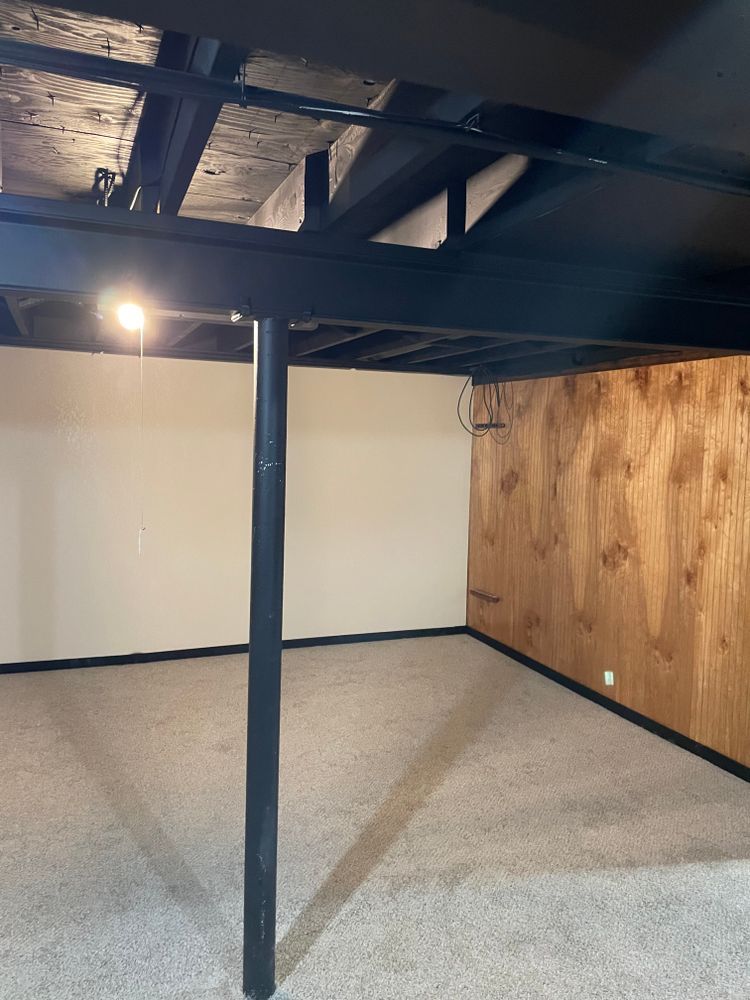 An empty basement with a wooden wall and a black ceiling