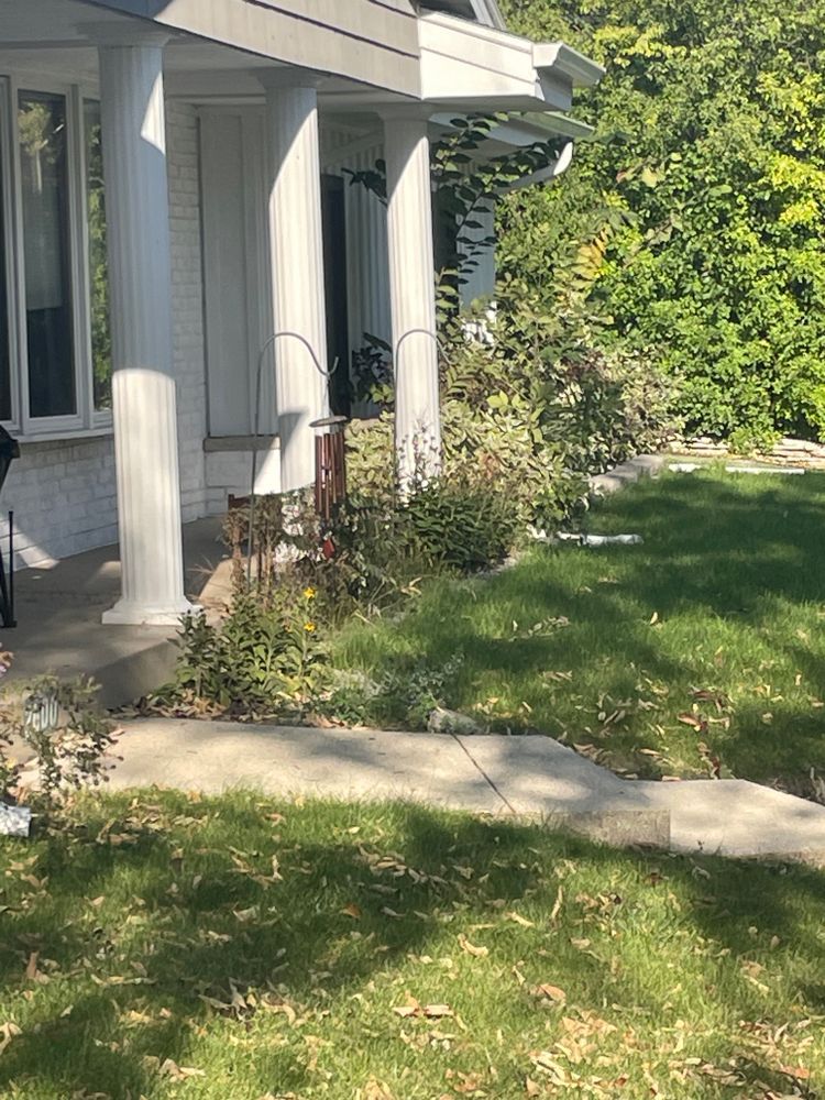 A white house with a porch and a lawn in front of it