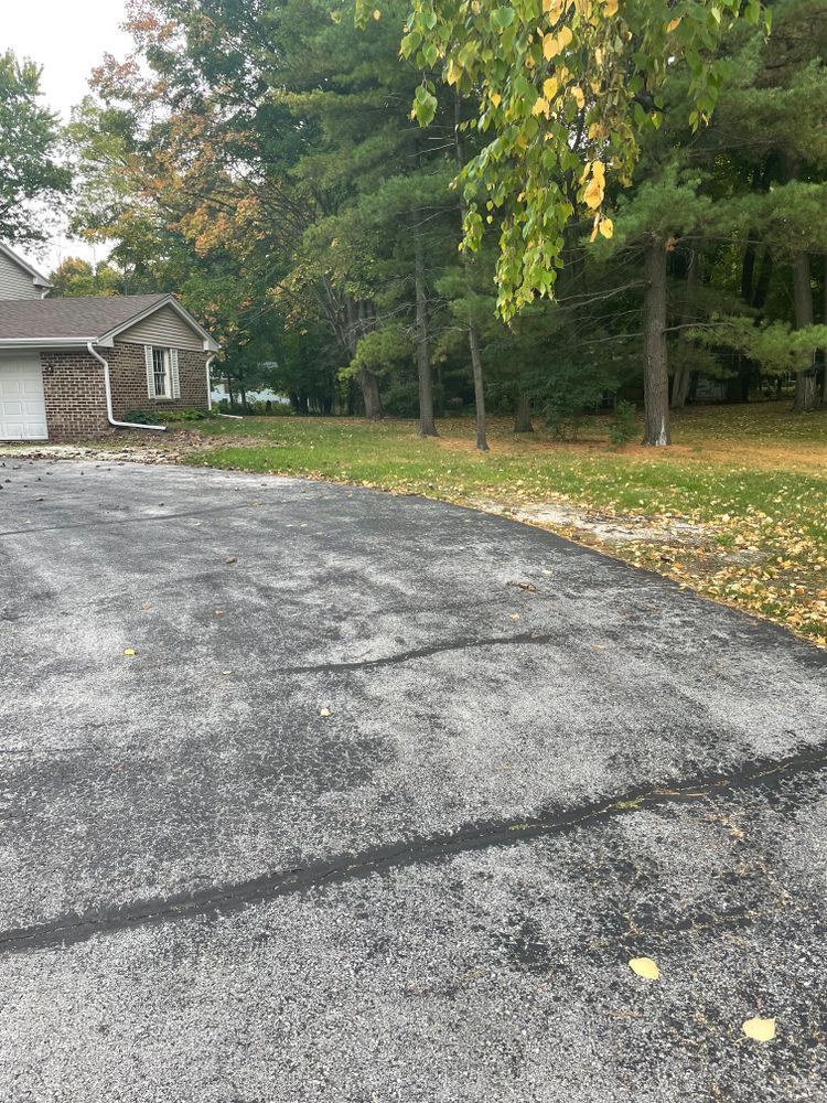 A driveway leading to a house with trees in the background