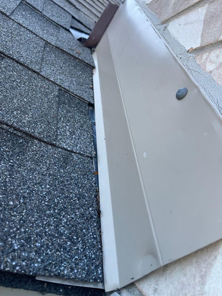 A close up of a roof with shingles and a metal trim
