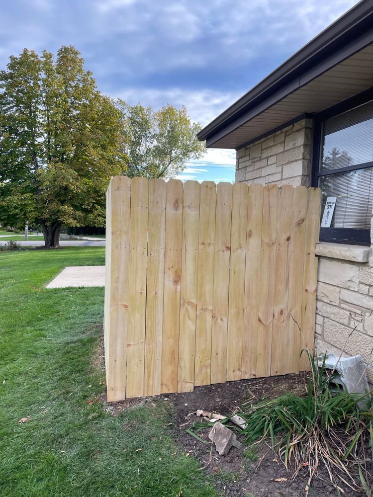 A wooden fence is sitting next to a brick house