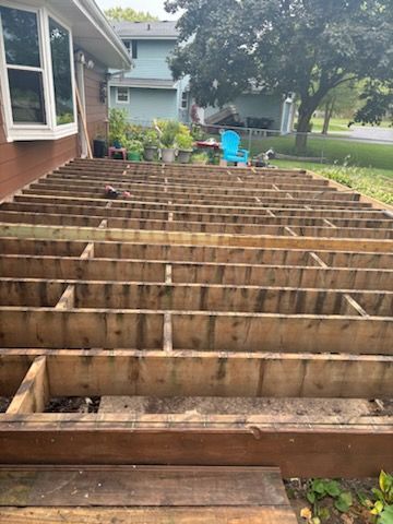 A wooden deck is being built in front of a house