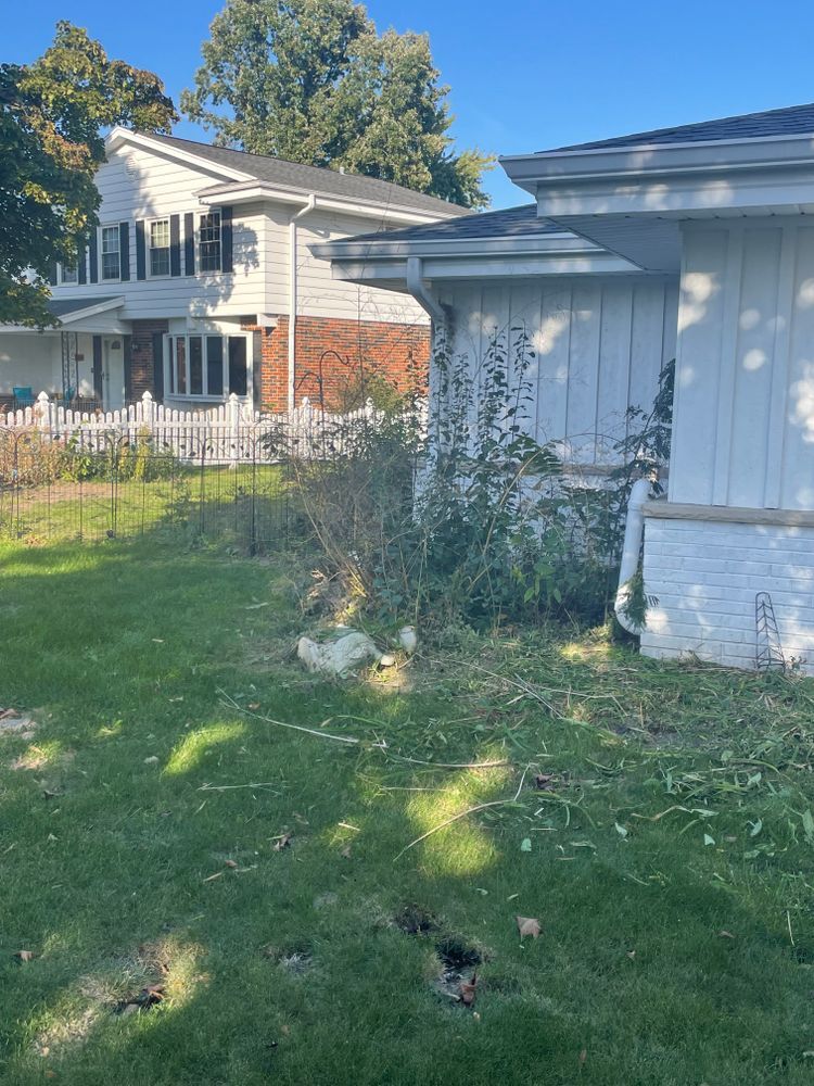 A white house with a white picket fence is sitting in the middle of a lush green yard