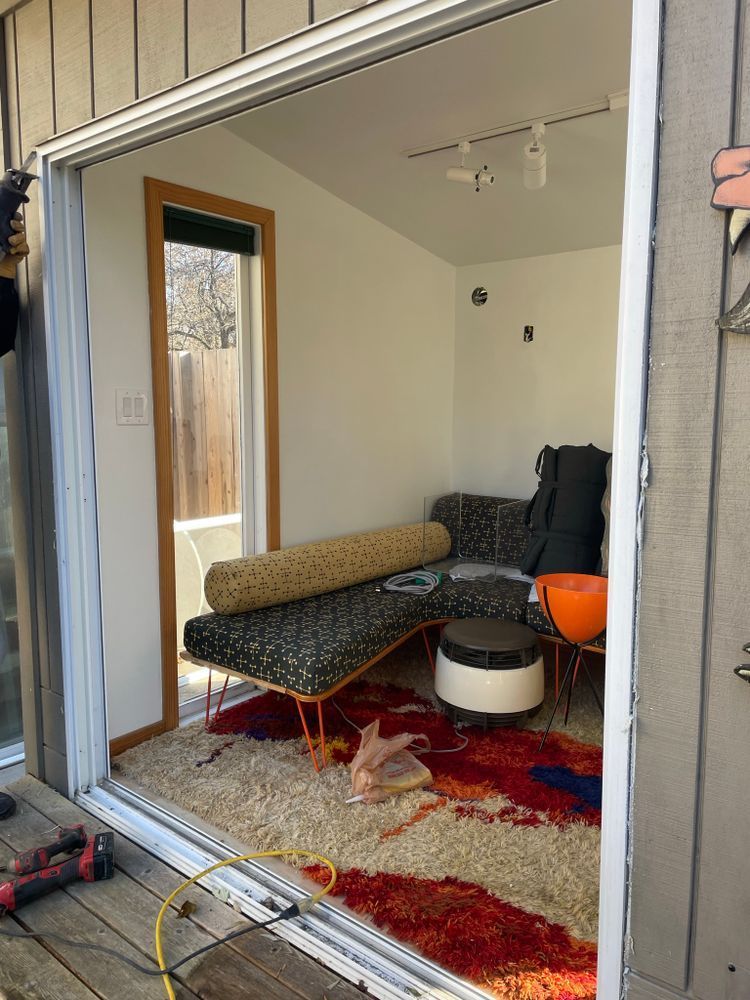 A man is installing a sliding glass door in a living room