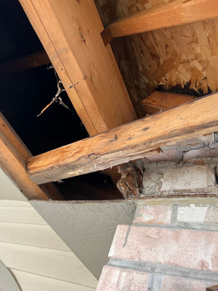 A brick wall with a wooden beam hanging from it